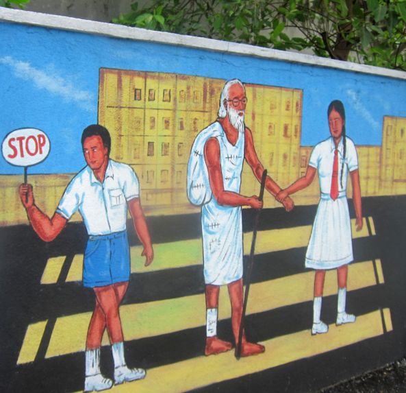 Переведи старика через дорогу. Агитационный плакат на заборе.  Шри-Ланка. Фото  Лимарева В.Н.